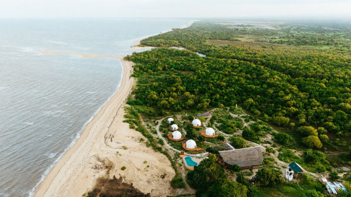 Cterra Saadani from the air: the six domes, the pool and the main house, with five kilometres of empty beach and the Indian Ocean beside them