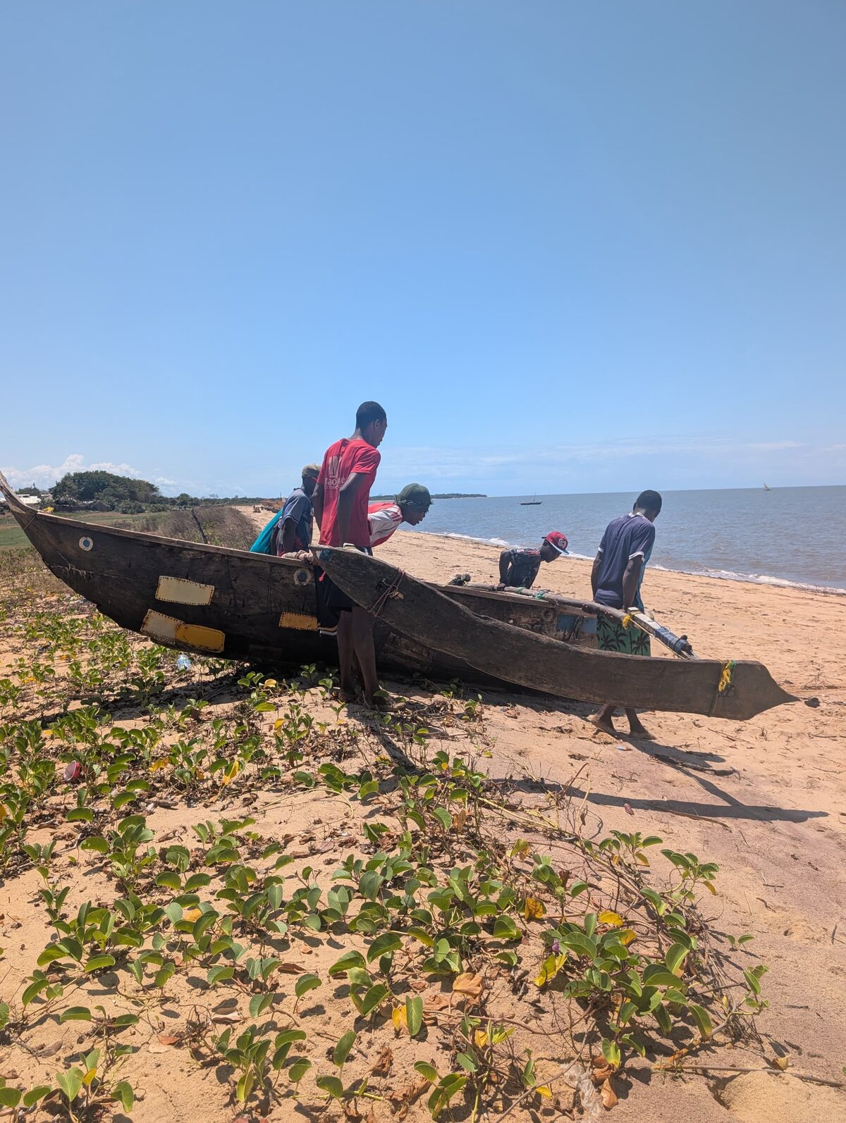 Local fishermen readying an outrigger canoe on the beach