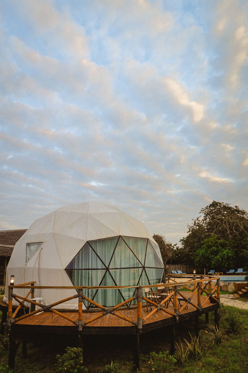 The domes from outside — The tented domes on their platforms, among the palms and facing the ocean.