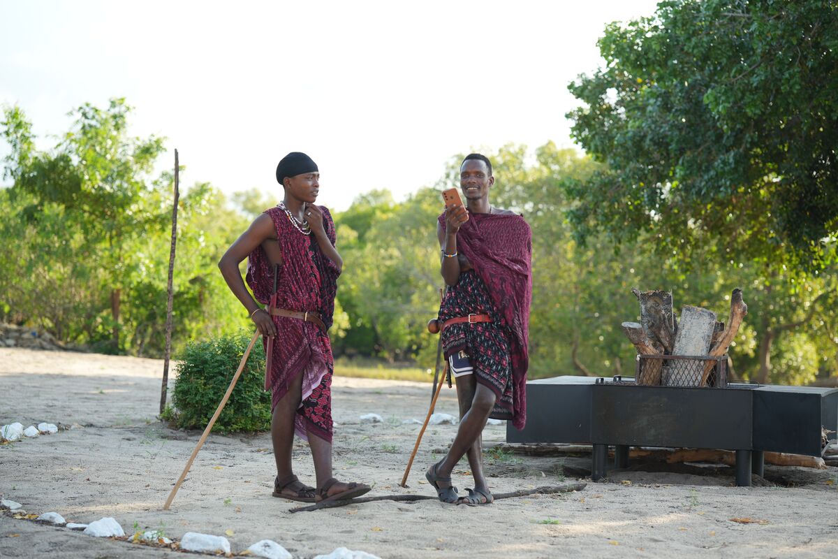 Two Maasai in red shukas on the sand in the afternoon