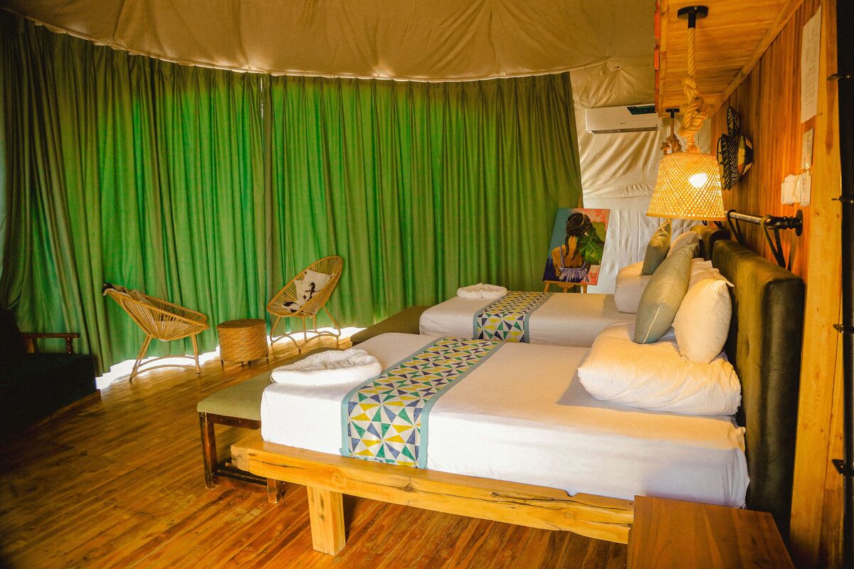 Inside a Family Garden dome at Cterra Saadani, made up as a double, with the ladder to the loft