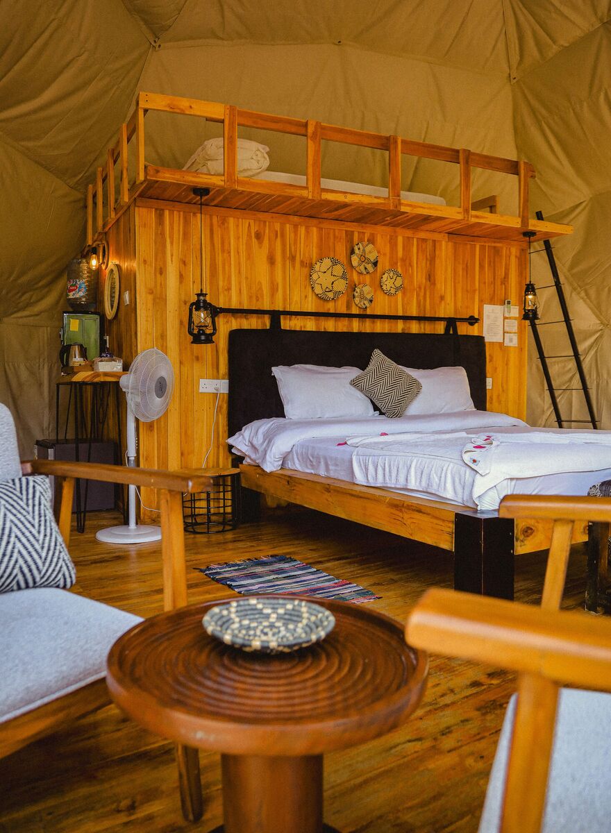Inside a Family Garden dome at Cterra Saadani, made up as a double, with the ladder to the loft