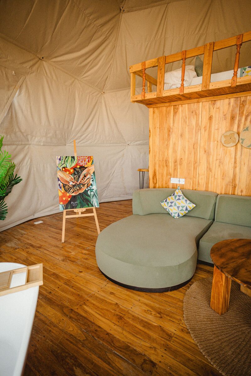 The Honey Suite at Cterra Saadani, with the green sofa and the freestanding bath