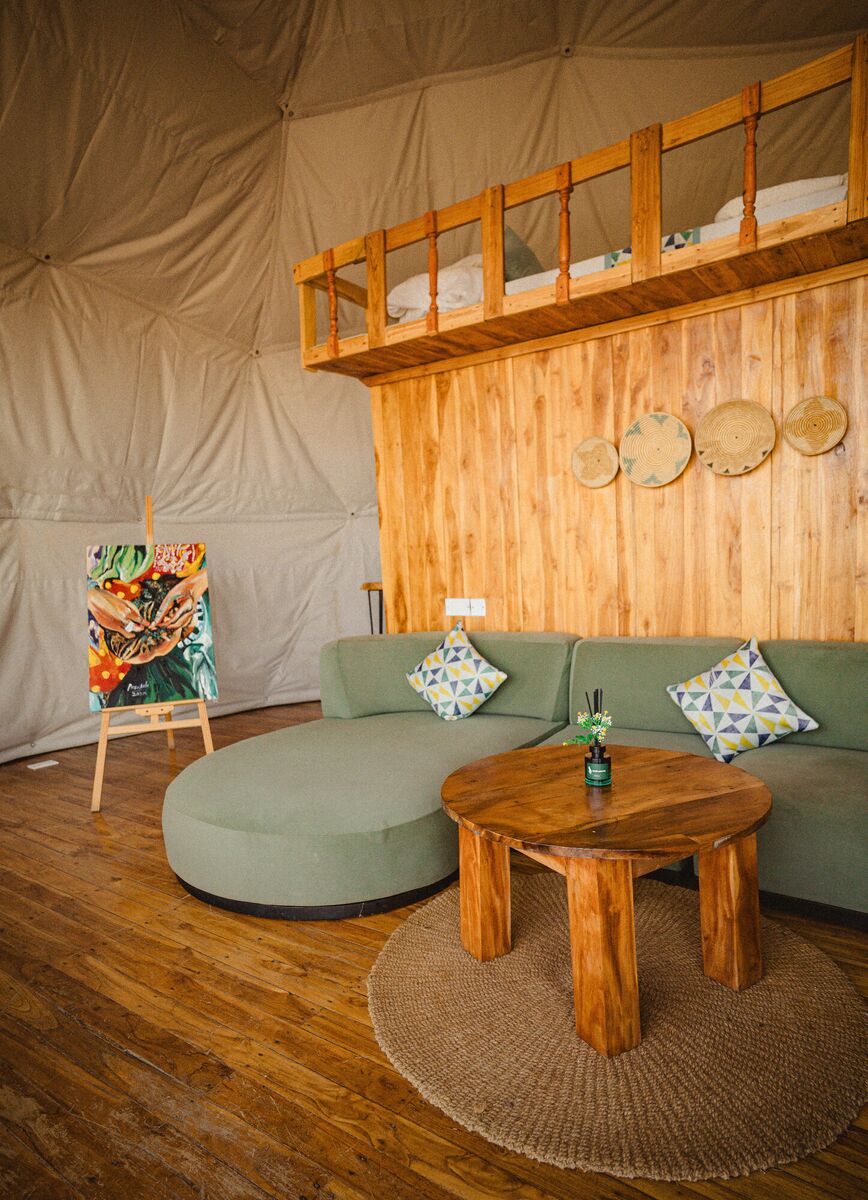 The Honey Suite at Cterra Saadani, with the green sofa and the freestanding bath