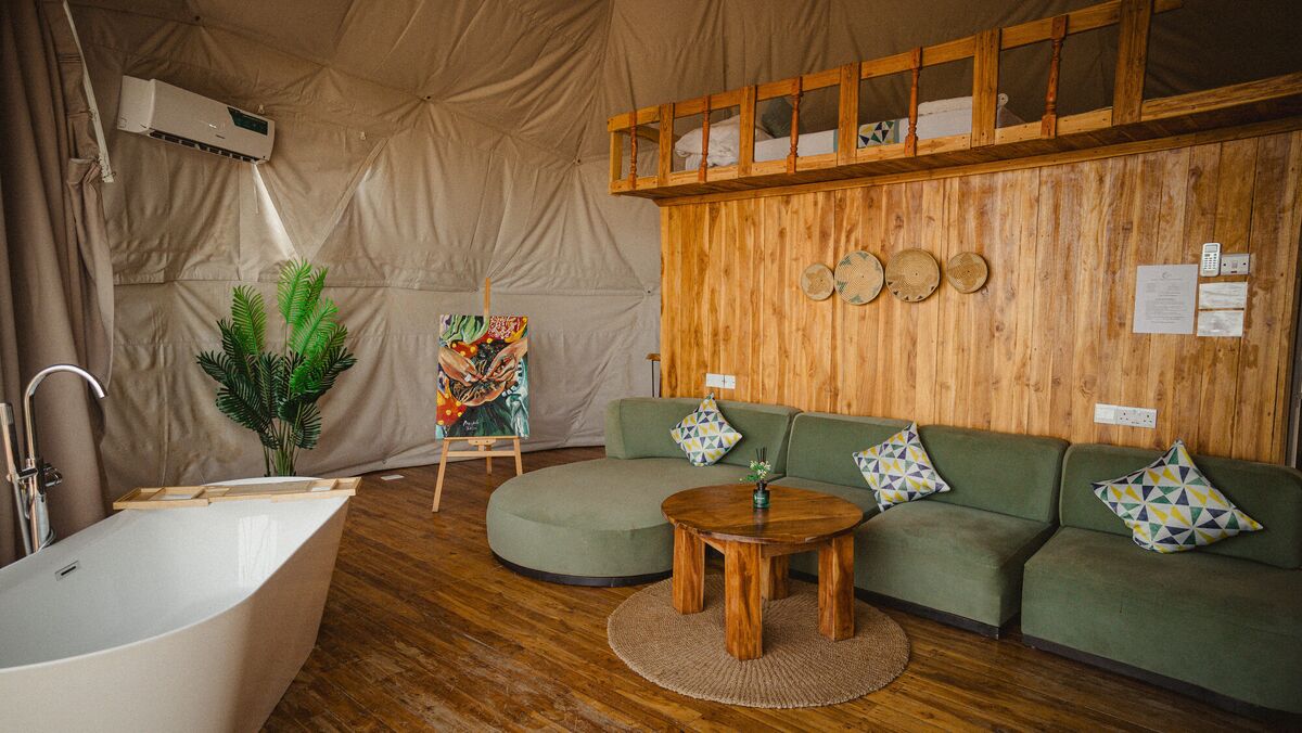 The Honey Suite at Cterra Saadani, with the green sofa and the freestanding bath