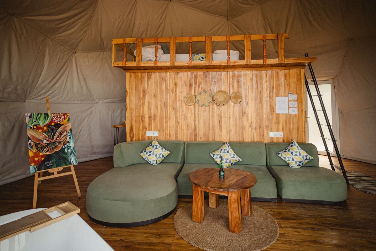 The Honey Suite at Cterra Saadani, with the green sofa and the freestanding bath
