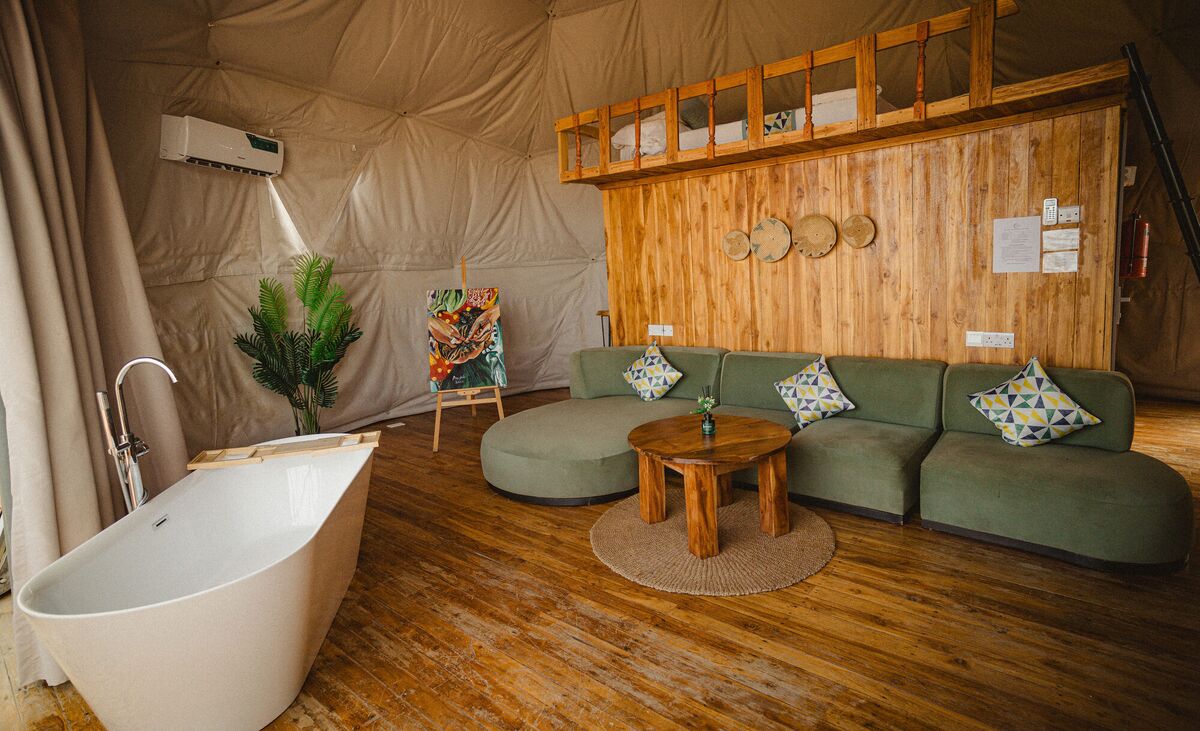 The Honey Suite at Cterra Saadani, with the green sofa and the freestanding bath