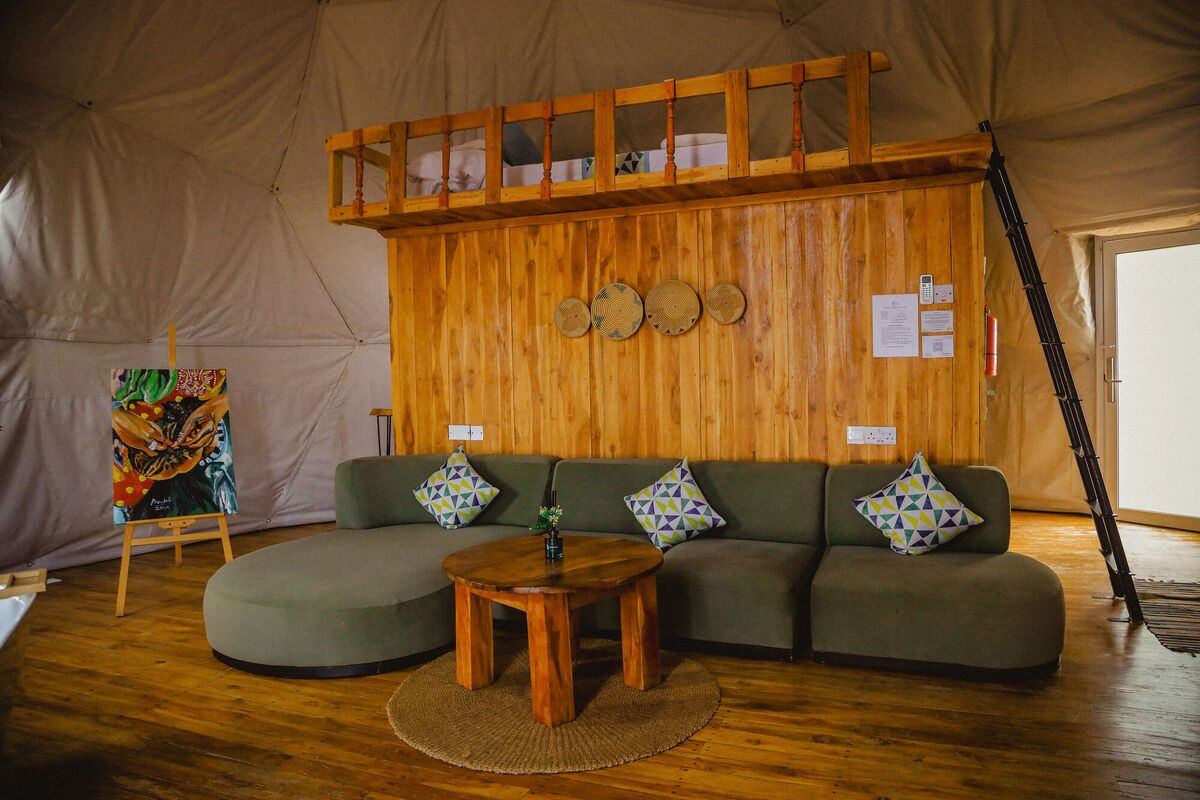 The Honey Suite at Cterra Saadani, with the green sofa and the freestanding bath