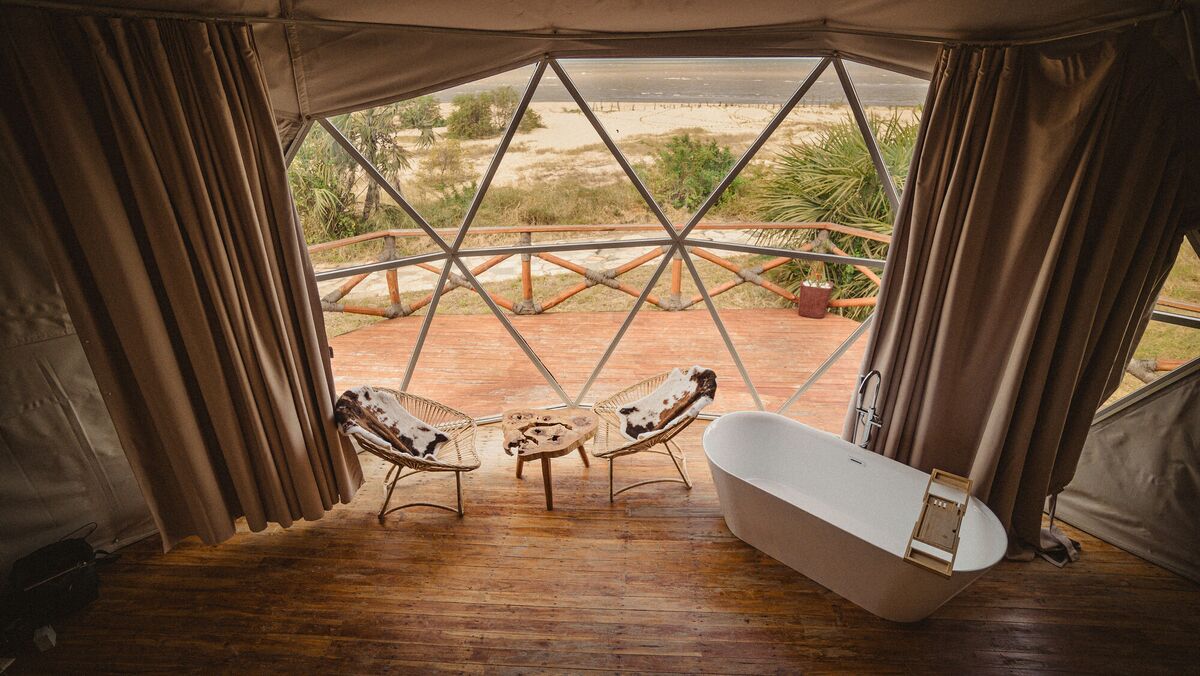The freestanding bath of the Honey Suite, facing the glazed wall and the deck