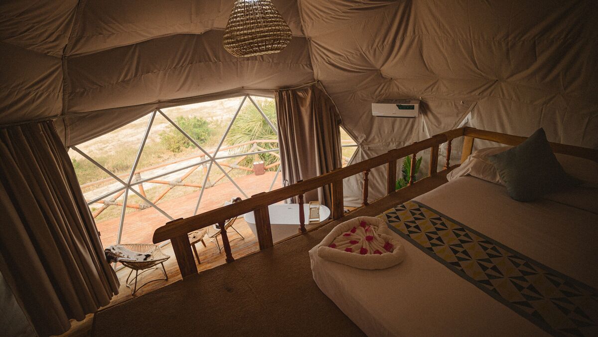The freestanding bath of the Honey Suite, facing the glazed wall and the deck