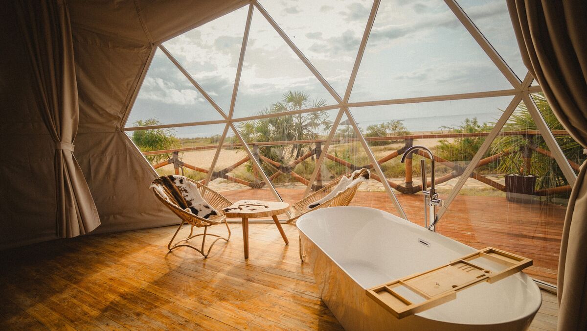 The freestanding bath of the Honey Suite, facing the glazed wall and the deck