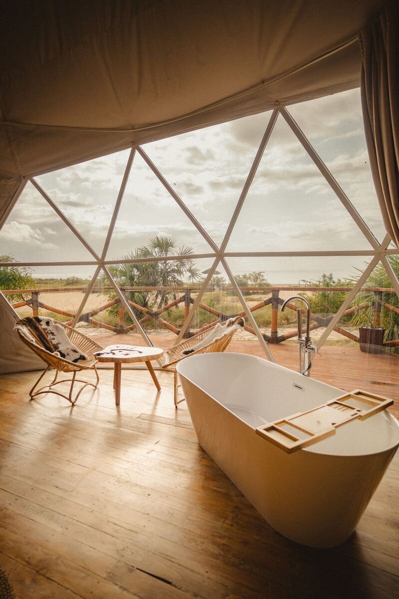 The freestanding bath of the Honey Suite, facing the glazed wall and the deck