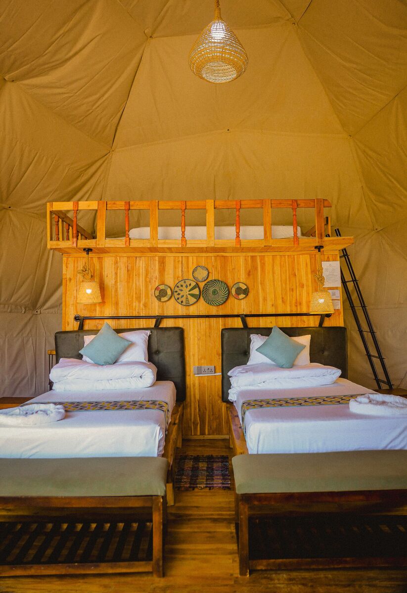 Inside the Twin dome at Cterra Saadani, with the separate beds and the woven plates on the timber wall