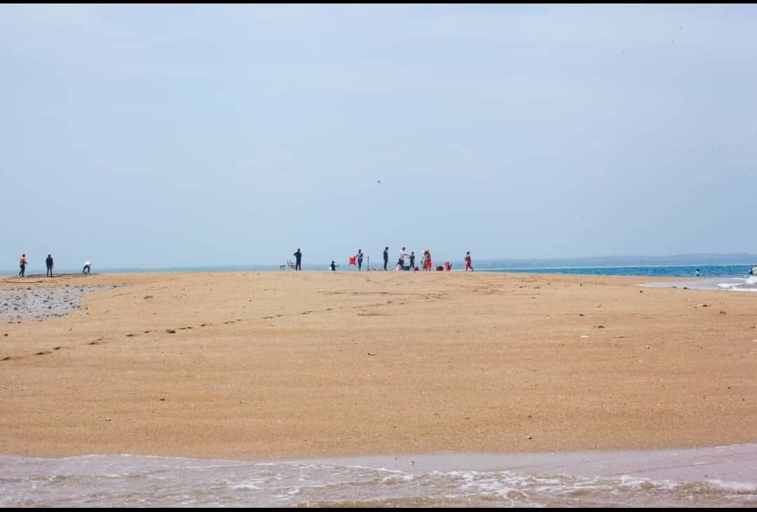 Guests standing on the Mafui sandbank at low tide, with the Indian Ocean on both sides