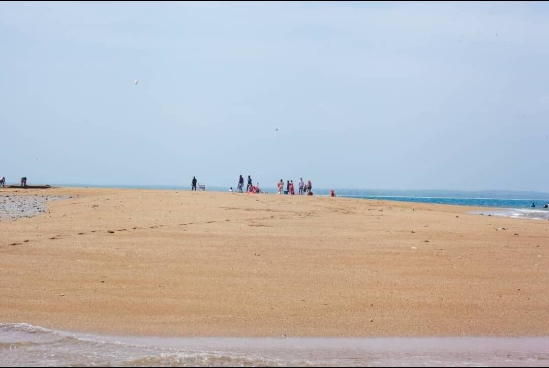 The Mafui sandbank surfacing as the tide goes out, with a boat moored alongside