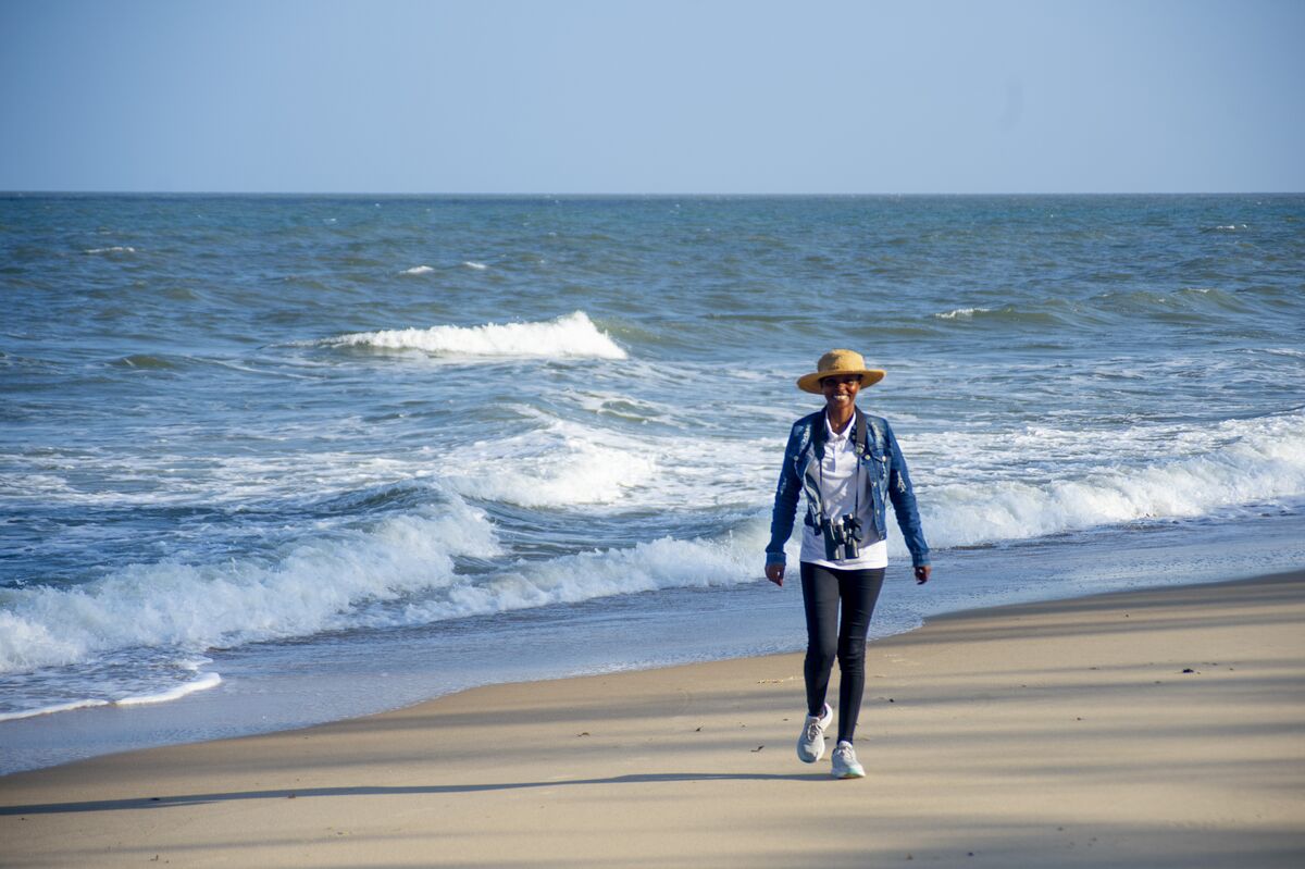 A guest walking the empty beach in front of the camp