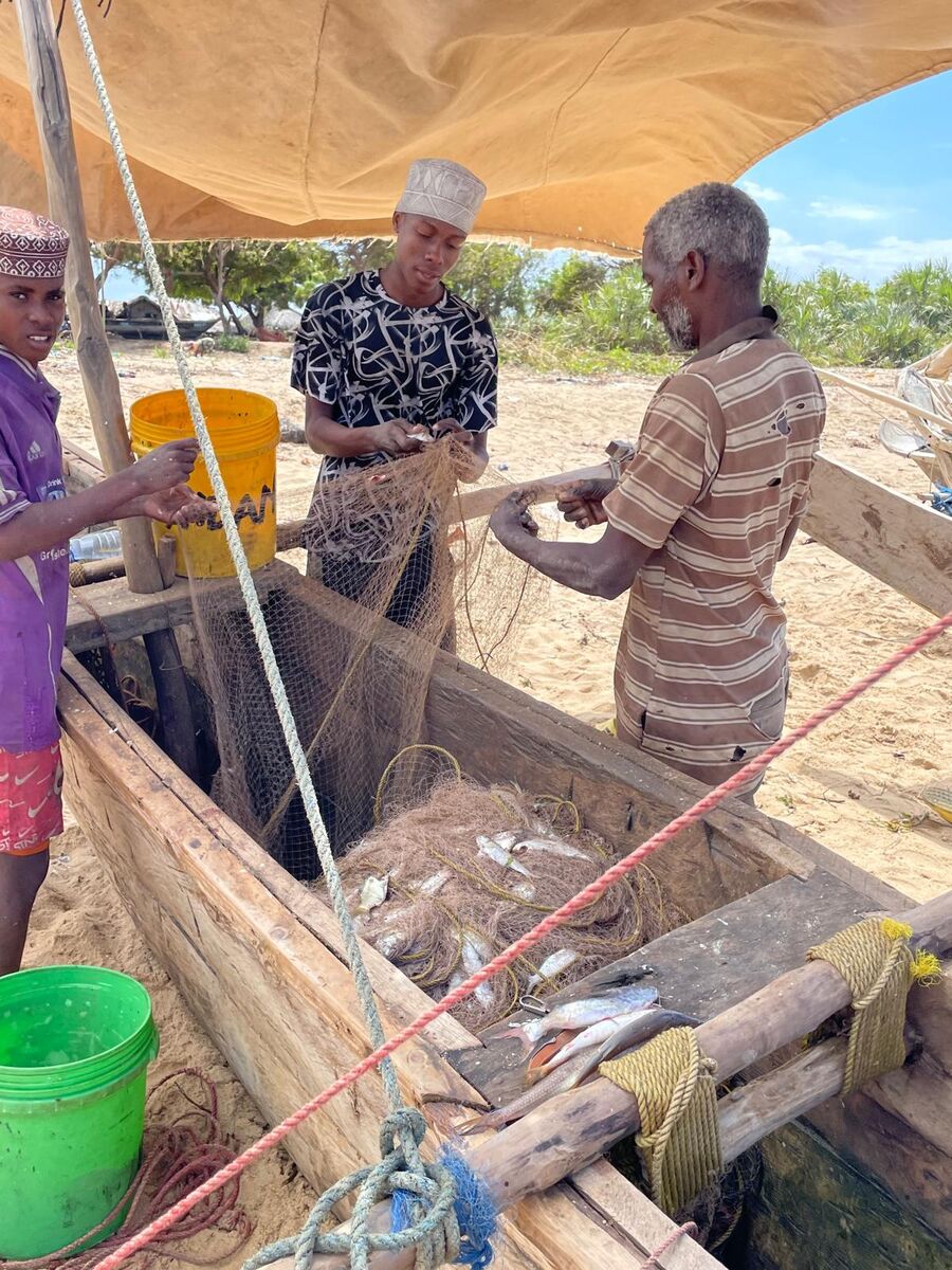 The village and the coast — Buyuni next door, a Swahili door, and a dhow on the sand at low tide.