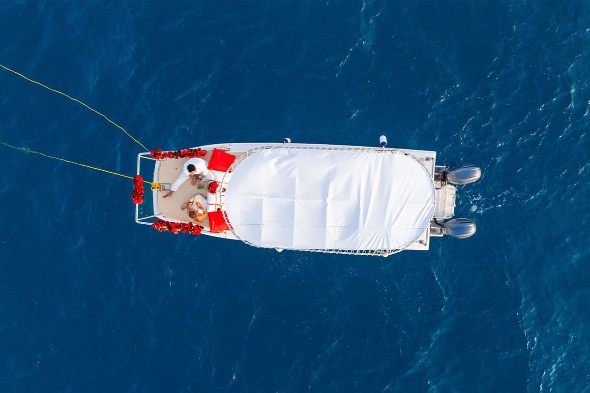 The boat from directly overhead on deep blue water, the canopy filling the frame