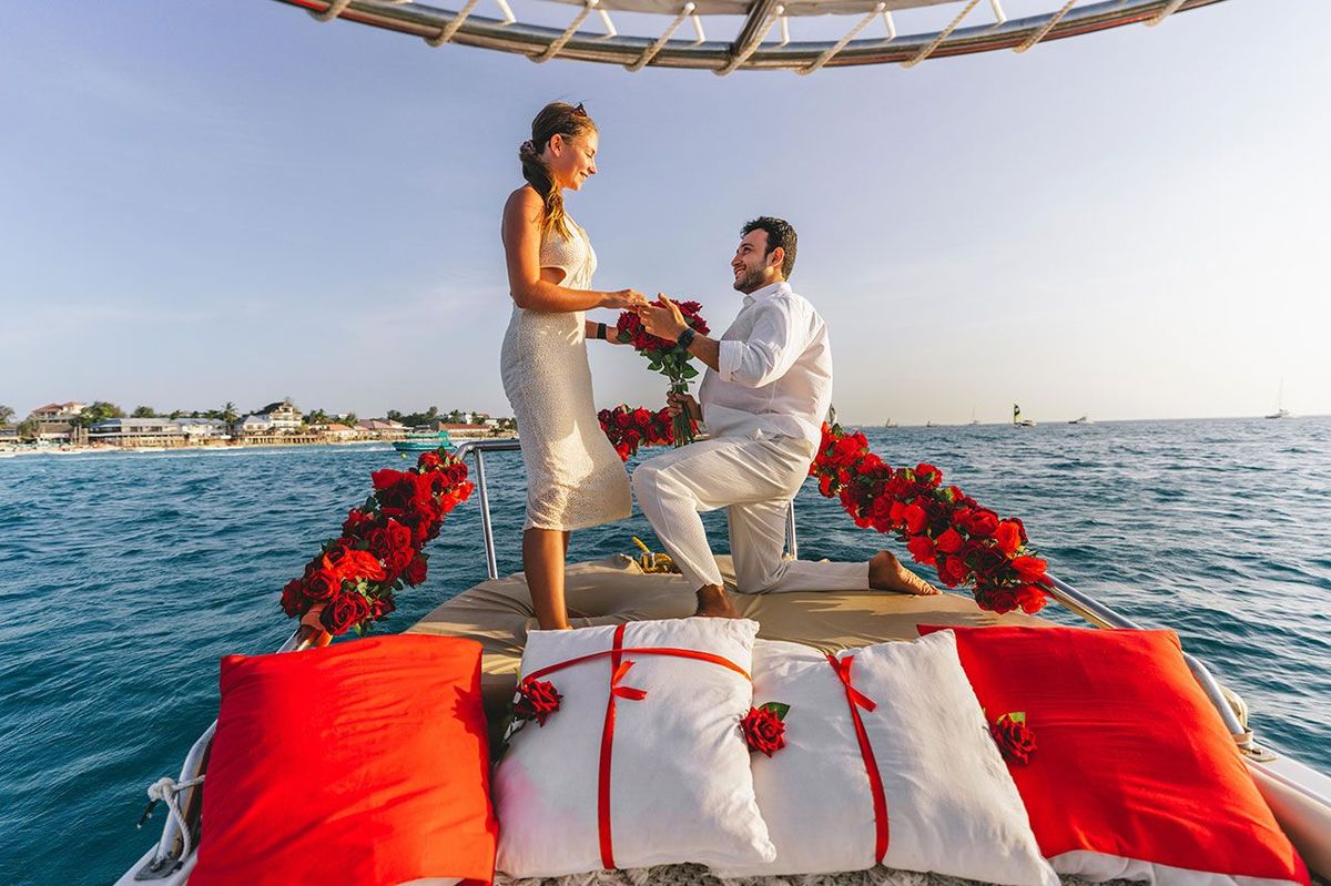 A marriage proposal on the bow, the deck dressed with roses and petals
