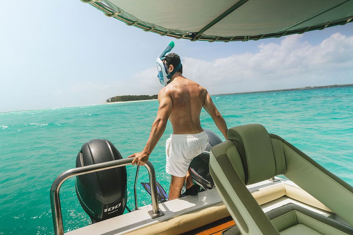 A guest in a snorkelling mask at the stern, about to go in
